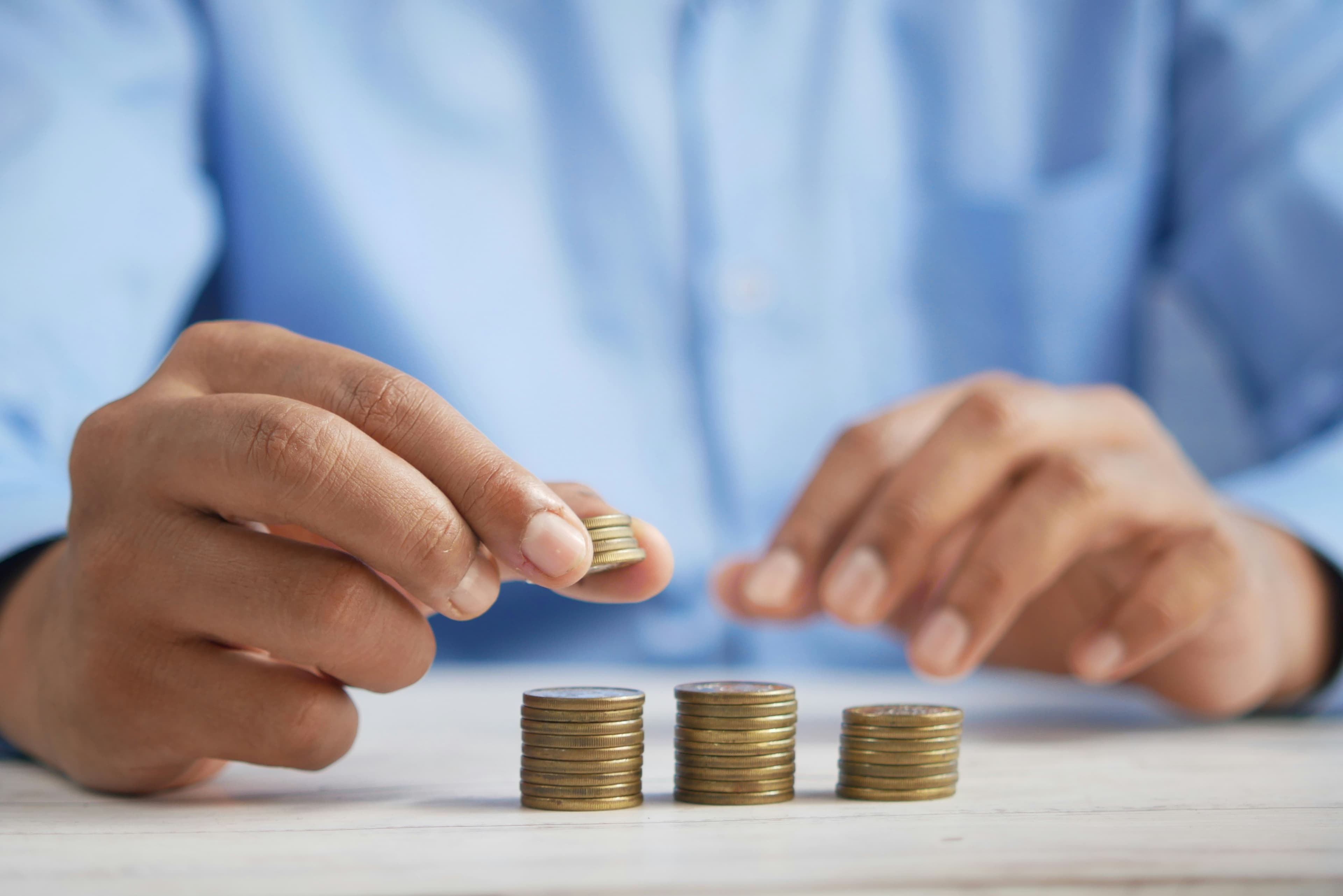 Hands stacking coins — government grant and financial advisory